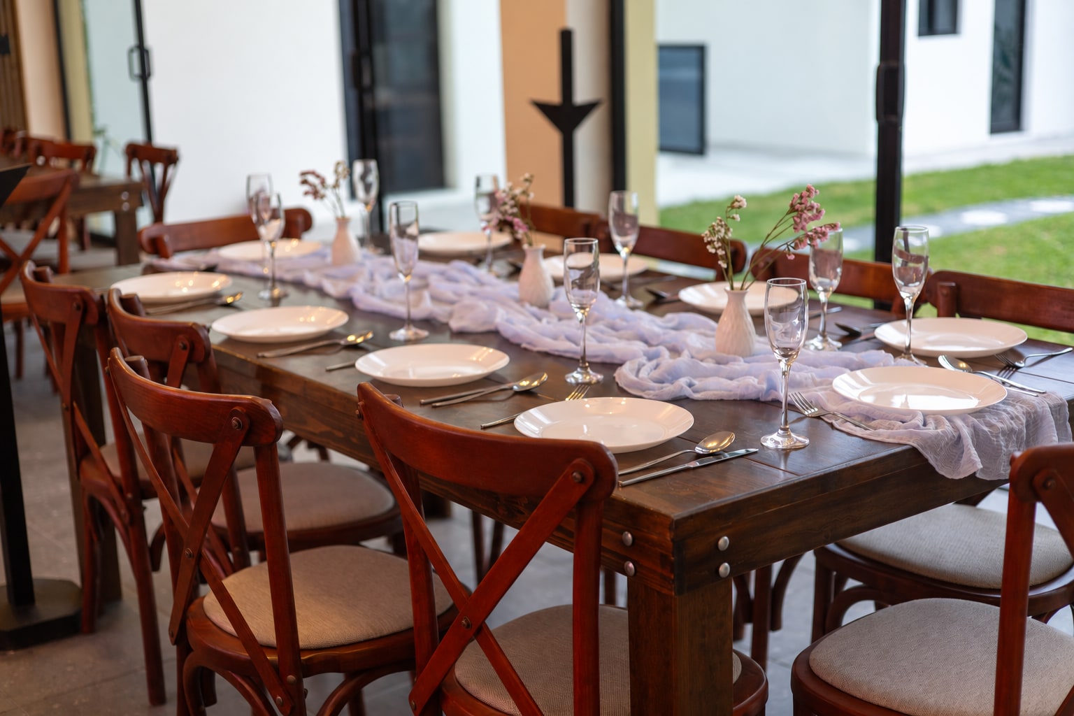 Mesa de madera con montaje y vista al jardín de Yalduna