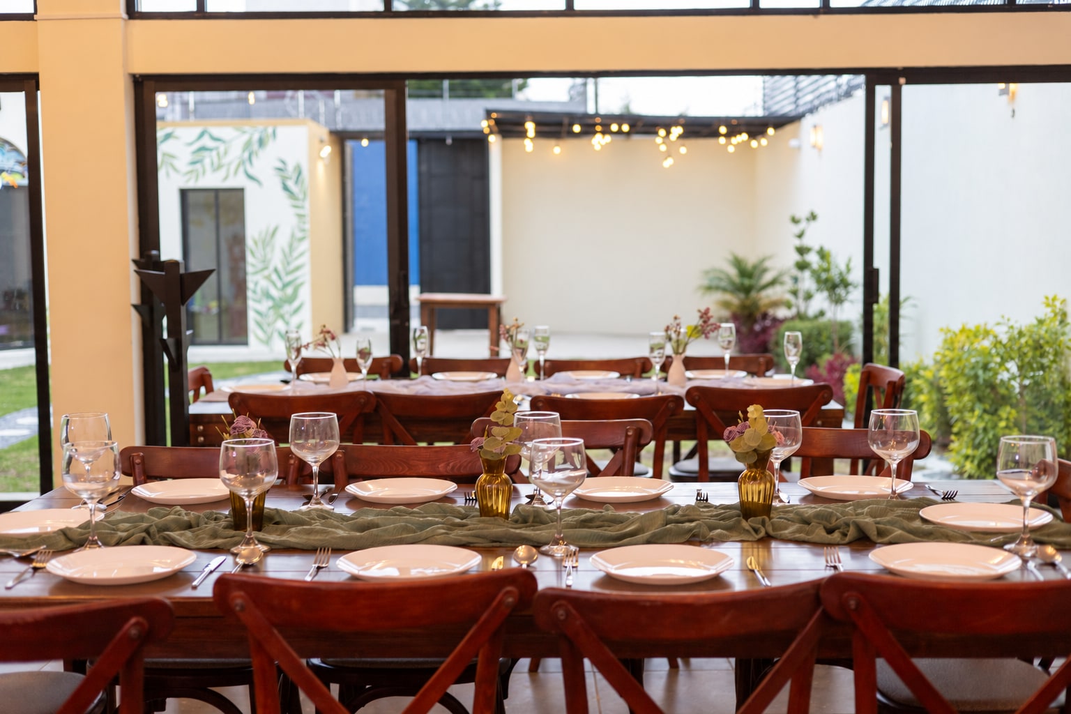Interior de Yalduna con mesas de madera y ventanales hacia el jardín